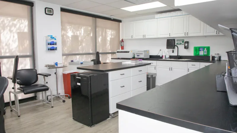 Entrust laboratory with white cabinetry, work surfaces, and specimen processing equipment