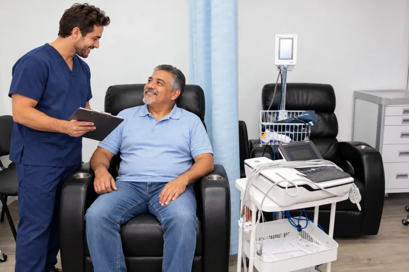 Modelo de un hombre conversando sobre un estudio con un coordinador en la sala de sillones reclinables de Entrust